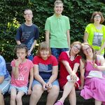 Grupa uczniów pozuje do zdjęcia w scenerii parkowej.