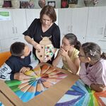 Nauczycielka demonstruje uczniom sposób wykonania pracy.