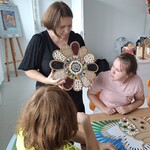 Nauczycielka demonstruje uczennicom sposób wykonania pracy.