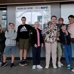 Grupa uczniów stojąca przy kasach dworca autobusowego.