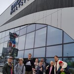Grupa uczniów stojąca przed dworcem autobusowym.