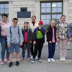 Grupa uczniów przed dworcem kolejowym.