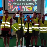 Grupa uczniów w odblaskowych kamizelkach.