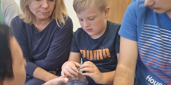 Uczeń szuka w słoiku z hydrożelem zwierząt mieszkających w wodzie.