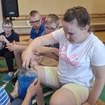 Uczennica szuka w słoiku z hydrożelem zwierząt mieszkających w wodzie.