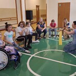 Uczniowie podczas warsztatów. Nauczycielka pokazuje żółty worek do zbierania plastiku.