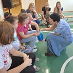 Uczeń szuka w słoiku z hydrożelem zwierząt mieszkających w wodzie. Obok siedzą uczniowie i nauczyciele biorący udział w warsztatach.