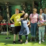 Grupa uczniów i nauczycielka na tle wystawy.
