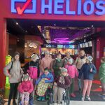 Grupa uczniów i nauczycielki stoją w wejściu do kina Helios.