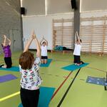 Uczniowie na matach wykonują ćwiczenie zgodnie z instrukcją nauczyciela.