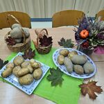 Na stole stoją talerze i koszyczki z ziemniakami.