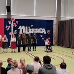 Społeczność szkolna ogląda występ kolegów, na tle dekoracji z napisem 11 listopada.