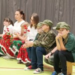Uczniowie siedzą na ławeczce.