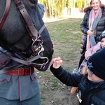 Uczeń wyciąga dłoń w stronę głowy konia.