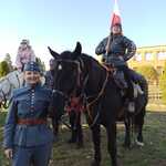 Uczennica siedzi na koniu i trzyma flagę Polski.