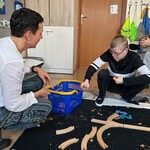 Uczeń wkłada drewniany klocek do pudełka.