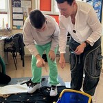 Uczeń wkłada drewniany klocek do pudełka.
