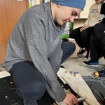 Uczeń zamiata suche liście.