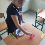 Uczennica stawia kubek na stole.