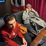 Uczniowie siedzą na kanapie przed wejściem na seans.