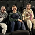 Uczniowie siedzą w sali kinowej.
