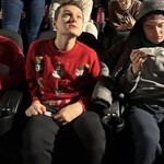 Uczniowie siedzą w sali kinowej.