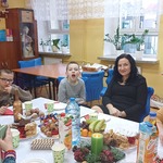 Uczniowie i ich mamy przy wigilijnym stole.