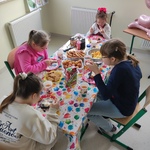 Uczennice siedzą wokół urodzinowego stołu.