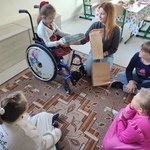 Jubilatka otwiera prezenty. Wokół siedzą koleżanki.
