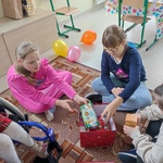 Uczennice wkładają rzeczy zamówione w liście do Św. Mikołaja do  pudełka.