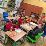 grupa uczniów i nauczycielka w świątecznych sweterkach.