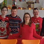 Grupa uczniów i nauczycielka w świątecznych sweterkach.