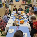 Uczniowie siedzą przy wigilijnym stole.