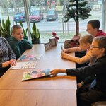 Nauczycielka i uczniowie siedzą przy stole w pizzerni.