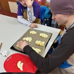 Uczeń układa pokrojone jabłka na blaszce