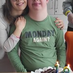 Jubilat z koleżanką. przed nimi na stole stoi tort urodzinowy.
