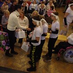 Grupa uczniów odbiera upominek od organizatora imprezy