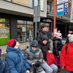 Grupa uczniów siedzi na przystanku autobusowym