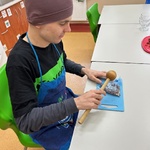 Uczeń uderzając tłuczkiem rozdrabnia orzechy.