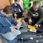 Uczniowie wkładają kartki do kopert