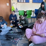 Uczniowie przyklejają symbole do pocztówki walentynkowej