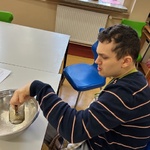 Uczeń wsypuje mąkę do miski