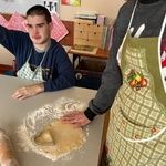 Uczeń stoi przy rozwałkowanym cieście