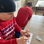 Uczeń smaruje ciasteczko marmoladą