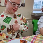 Uczeń siedzi przy stole. Przed nim stoi talerz z pizzą