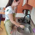 Uczennica zmywa przy zlewie