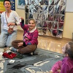 Uczennica demonstruje pozostałym uczniom symbol z cyfrą siedem