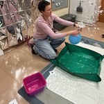 Nauczyciel trzyma lejek i balon, wokół fruną srebrne papierki imitujące spadający śnieg