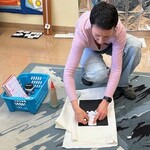 Nauczyciel demonstruje pracę samodzielną, przykleja elementy domu