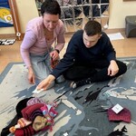 Uczeń kładzie symbol na zbiorze z  czapkami